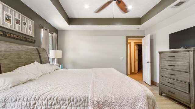 241 Mullet Dr, Freeport, FL 32439 - bedroom with light wood-type flooring, a tray ceiling, a ceiling fan, and baseboards