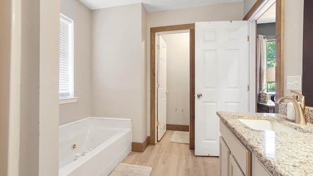 241 Mullet Dr, Freeport, FL 32439 - bathroom with vanity, a jetted tub, wood finished floors, and baseboards