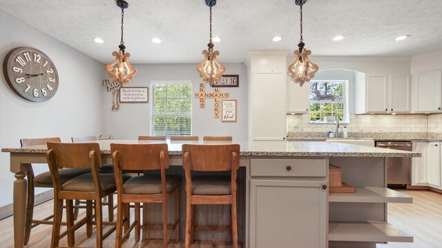 241 Mullet Dr, Freeport, FL 32439 - kitchen with dishwasher, light wood-style flooring, backsplash, a breakfast bar, and recessed lighting