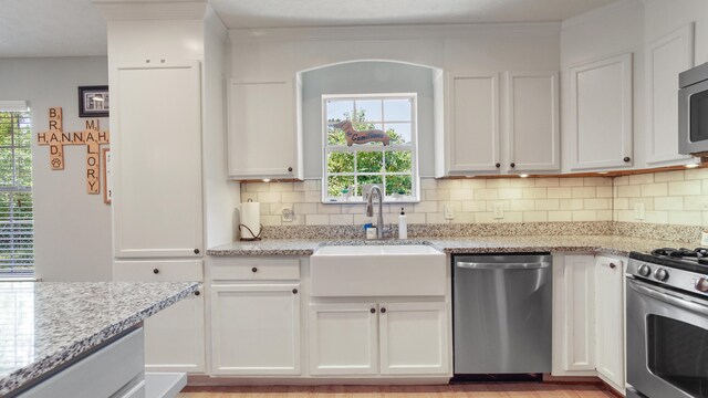 241 Mullet Dr, Freeport, FL 32439 - kitchen featuring appliances with stainless steel finishes, a sink, tasteful backsplash, and white cabinets