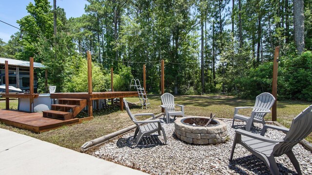 241 Mullet Dr, Freeport, FL 32439 - view of patio featuring an outdoor fire pit, a wooden deck, and view of scattered trees