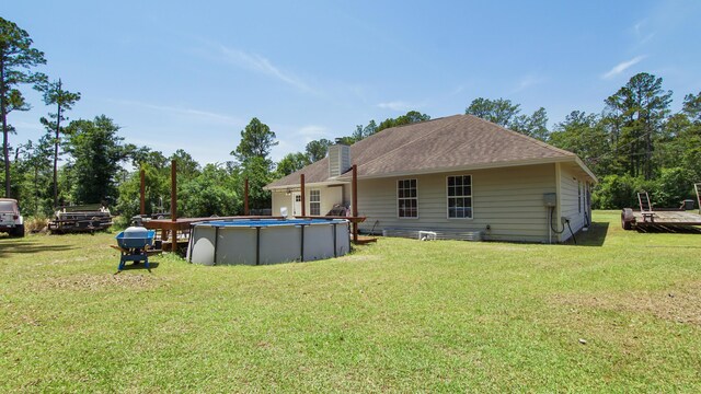 241 Mullet Dr, Freeport, FL 32439 - back of property with a yard, a chimney, and an outdoor pool