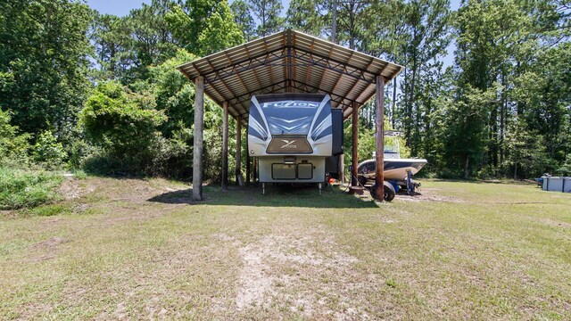 241 Mullet Dr, Freeport, FL 32439 - view of grassy yard with a carport, driveway, and view of scattered trees