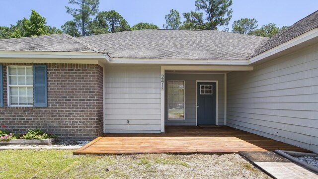 241 Mullet Dr, Freeport, FL 32439 - entrance to property with a deck, a shingled roof, and brick siding