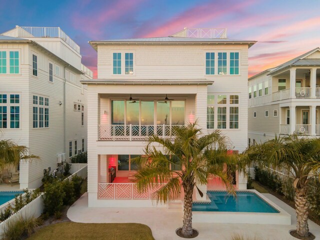 35 Pompano St, Inlet Beach, FL 32461 - back of property at dusk featuring a balcony, an outdoor pool, and ceiling fan