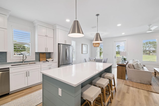 278 Dockside Dr, Port St Joe, FL 32456 - kitchen featuring stainless steel appliances, light wood finished floors, light countertops, open floor plan, and recessed lighting