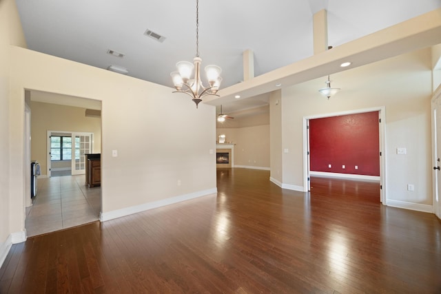 201 Pinque Coat Ct, Crestview, FL 32536 - unfurnished living room featuring a warm lit fireplace, a chandelier, hardwood / wood-style flooring, recessed lighting, and a towering ceiling