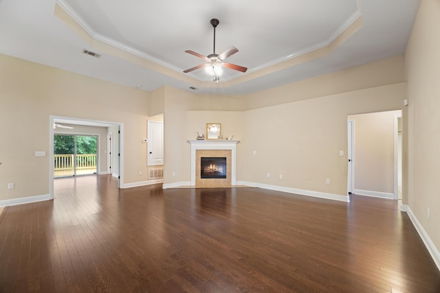 201 Pinque Coat Ct, Crestview, FL 32536 - unfurnished living room featuring a raised ceiling, ceiling fan, dark wood-type flooring, a tile fireplace, and crown molding