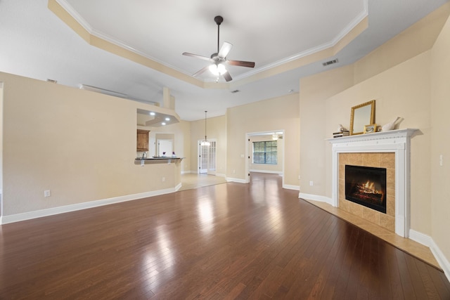 201 Pinque Coat Ct, Crestview, FL 32536 - unfurnished living room featuring ceiling fan, a raised ceiling, a fireplace, crown molding, and wood-type flooring