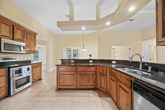 201 Pinque Coat Ct, Crestview, FL 32536 - kitchen with stainless steel appliances, brown cabinets, a chandelier, dark stone counters, and light tile patterned flooring
