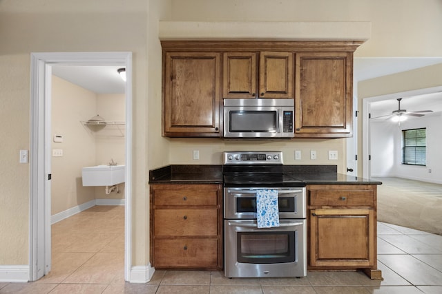 201 Pinque Coat Ct, Crestview, FL 32536 - kitchen featuring appliances with stainless steel finishes, brown cabinets, light tile patterned floors, and a ceiling fan