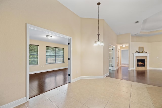 201 Pinque Coat Ct, Crestview, FL 32536 - unfurnished living room with tile patterned flooring, a chandelier, and a fireplace
