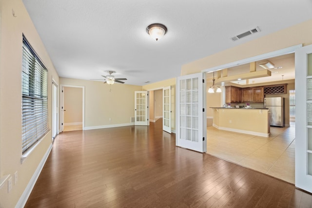 201 Pinque Coat Ct, Crestview, FL 32536 - unfurnished living room featuring french doors, wood-type flooring, a ceiling fan, and a chandelier
