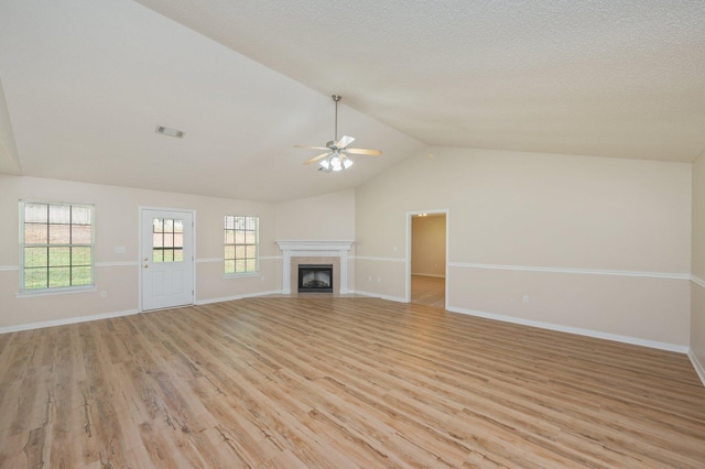 407 Tobago Ct, Crestview, FL 32536 - unfurnished living room with ceiling fan, light wood finished floors, baseboards, lofted ceiling, and a tiled fireplace
