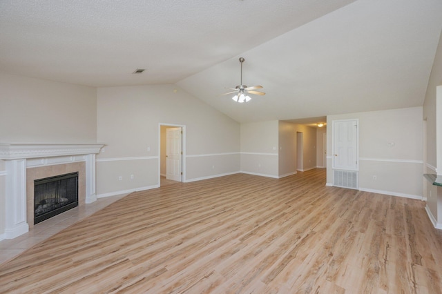 407 Tobago Ct, Crestview, FL 32536 - unfurnished living room featuring a ceiling fan, wood finished floors, a tile fireplace, vaulted ceiling, and baseboards