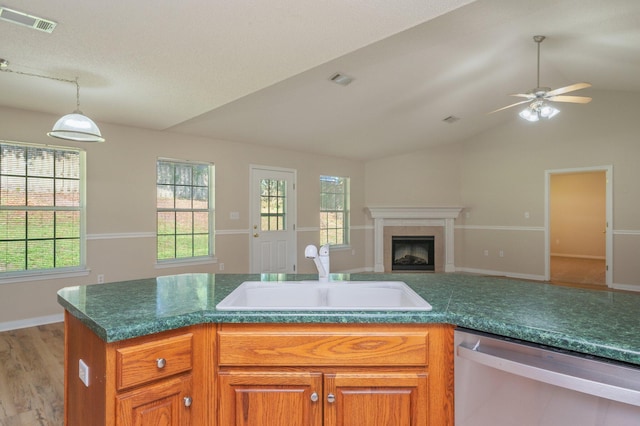 407 Tobago Ct, Crestview, FL 32536 - kitchen featuring stainless steel dishwasher, a sink, lofted ceiling, a tile fireplace, and open floor plan