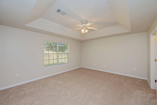 407 Tobago Ct, Crestview, FL 32536 - empty room featuring a raised ceiling, light colored carpet, a ceiling fan, baseboards, and a textured ceiling
