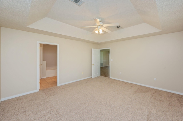 407 Tobago Ct, Crestview, FL 32536 - unfurnished bedroom with a raised ceiling, light carpet, a textured ceiling, baseboards, and ensuite bath