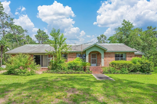 2226 W James Lee Blvd, Crestview, FL 32536 - ranch-style home featuring a front yard, brick siding, and a metal roof
