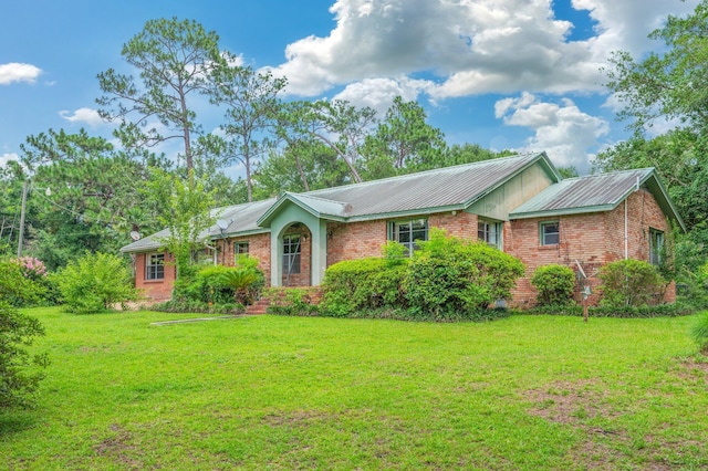 2226 W James Lee Blvd, Crestview, FL 32536 - ranch-style home with brick siding, a front lawn, and a metal roof