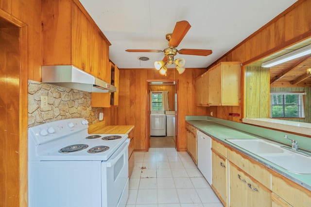 2226 W James Lee Blvd, Crestview, FL 32536 - kitchen with white appliances, under cabinet range hood, washer / dryer, plenty of natural light, and wooden walls