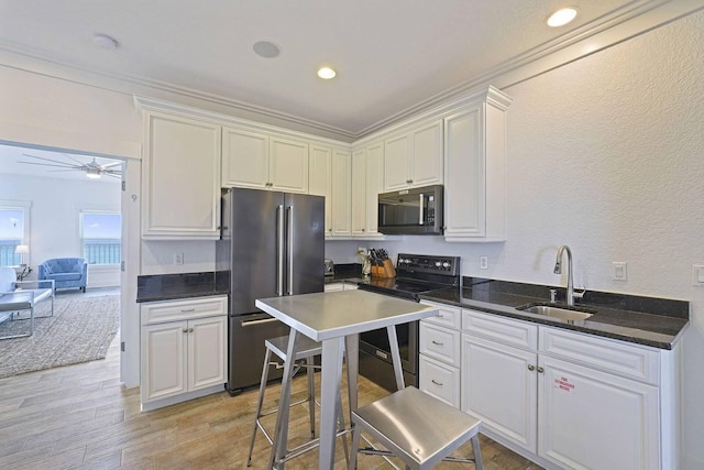 330 Tang O Mar Dr, Destin, FL 32550 - kitchen featuring stainless steel appliances, white cabinetry, ceiling fan, light wood-style floors, and a textured wall