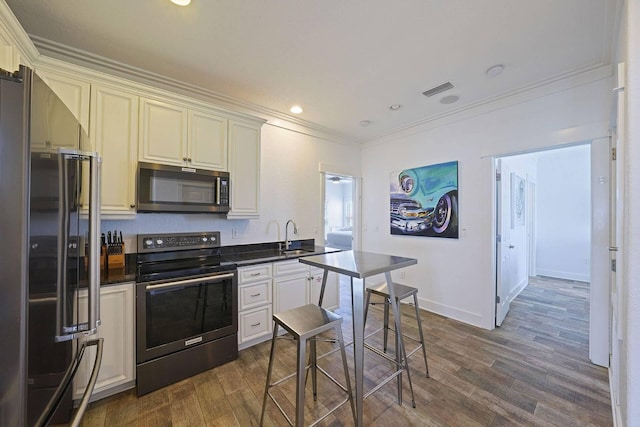330 Tang O Mar Dr, Destin, FL 32550 - kitchen featuring stainless steel appliances, dark countertops, ornamental molding, dark wood finished floors, and recessed lighting