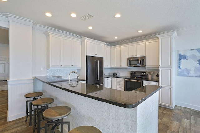 330 Tang O Mar Dr, Destin, FL 32550 - kitchen featuring appliances with stainless steel finishes, dark wood-style floors, a peninsula, backsplash, and recessed lighting