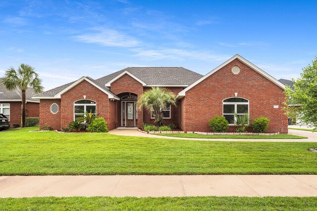 203 Landings Dr, Lynn Haven, FL 32444 - view of front of house with brick siding, a front yard, and roof with shingles