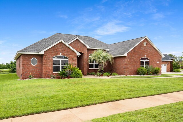 203 Landings Dr, Lynn Haven, FL 32444 - ranch-style home featuring brick siding, roof with shingles, a front yard, and a garage