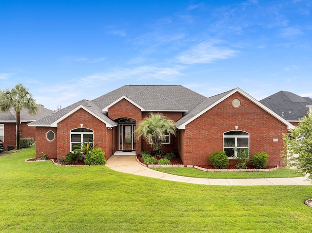 203 Landings Dr, Lynn Haven, FL 32444 - ranch-style home featuring brick siding, a front lawn, and roof with shingles