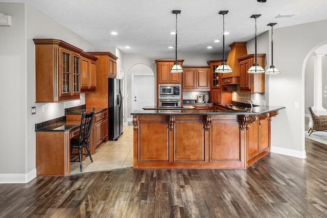 203 Landings Dr, Lynn Haven, FL 32444 - kitchen featuring appliances with stainless steel finishes, arched walkways, brown cabinets, baseboards, and recessed lighting