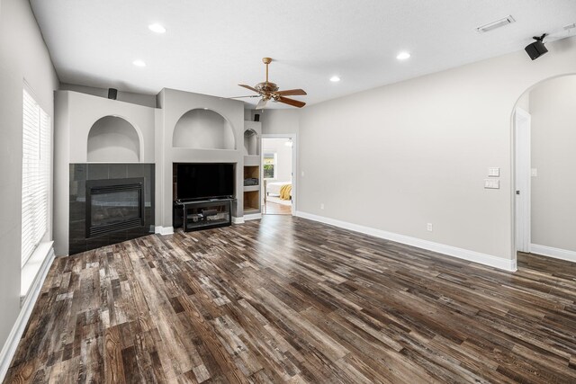 203 Landings Dr, Lynn Haven, FL 32444 - unfurnished living room featuring dark wood-type flooring, arched walkways, a ceiling fan, healthy amount of natural light, and recessed lighting
