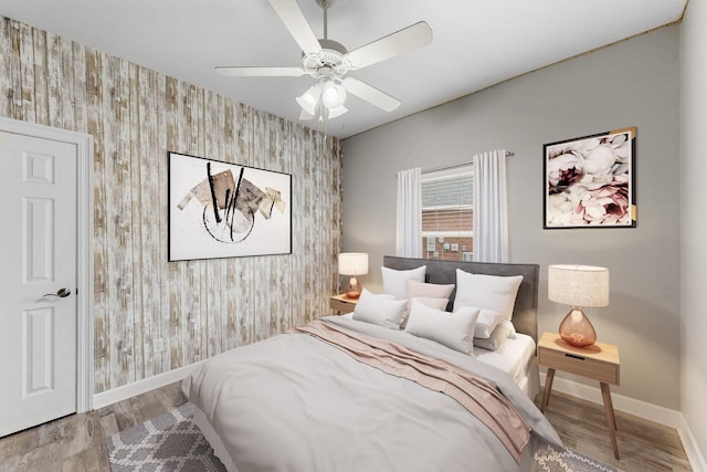 203 Landings Dr, Lynn Haven, FL 32444 - bedroom featuring an accent wall, wallpapered walls, baseboards, wood finished floors, and ceiling fan