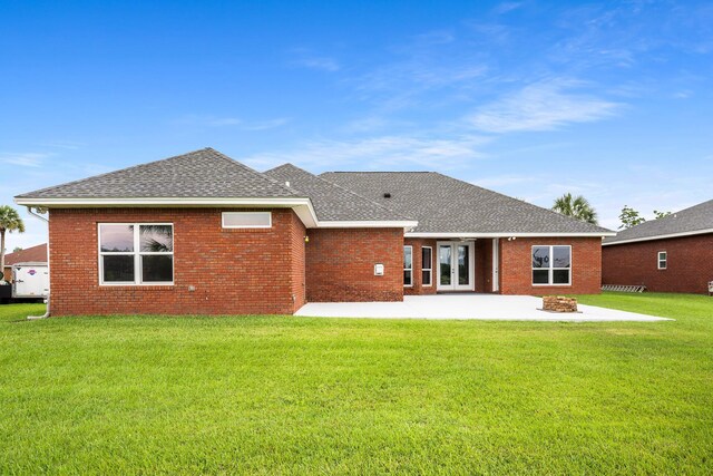 203 Landings Dr, Lynn Haven, FL 32444 - back of property featuring a shingled roof, a patio, a yard, and brick siding