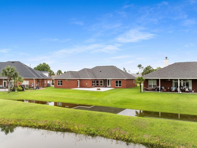 203 Landings Dr, Lynn Haven, FL 32444 - back of property with a patio area, a lawn, brick siding, and a water view