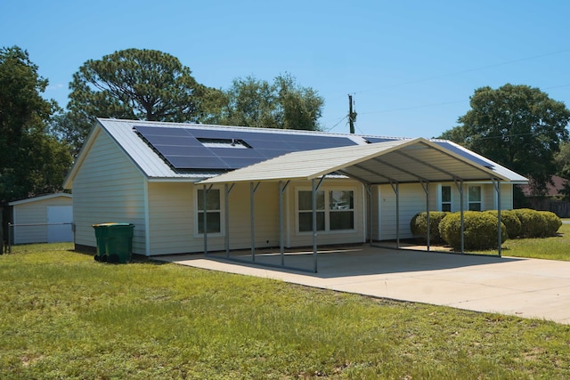 74 8th St, Shalimar, FL 32579 - rear view of house featuring a yard, roof mounted solar panels, concrete driveway, a detached carport, and a metal roof