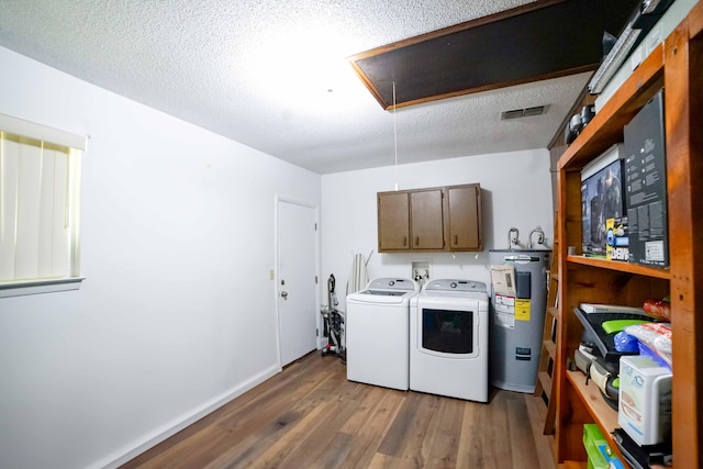 74 8th St, Shalimar, FL 32579 - washroom featuring attic access, water heater, independent washer and dryer, wood finished floors, and cabinet space