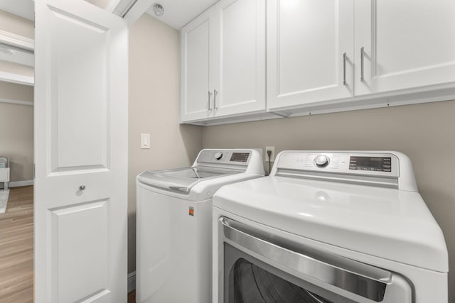 17281 Front Beach Rd Unit 1206, Panama City Beach, FL 32413 - washroom featuring cabinet space, washing machine and clothes dryer, and light wood finished floors