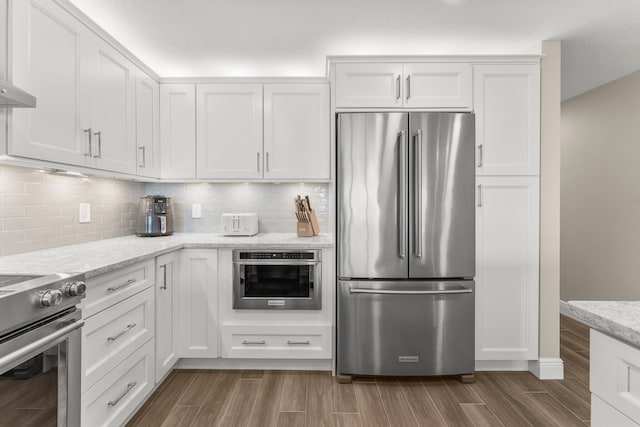 17281 Front Beach Rd Unit 1206, Panama City Beach, FL 32413 - kitchen with appliances with stainless steel finishes, white cabinets, wood finished floors, and tasteful backsplash