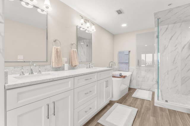 17281 Front Beach Rd Unit 1206, Panama City Beach, FL 32413 - bathroom featuring double vanity, a freestanding tub, a marble finish shower, wood finished floors, and recessed lighting