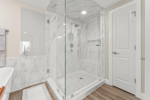17281 Front Beach Rd Unit 1206, Panama City Beach, FL 32413 - bathroom featuring a marble finish shower, wood finished floors, and a freestanding tub