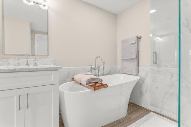 17281 Front Beach Rd Unit 1206, Panama City Beach, FL 32413 - bathroom with tile walls, vanity, wood tiled floors, a freestanding bath, and a shower stall