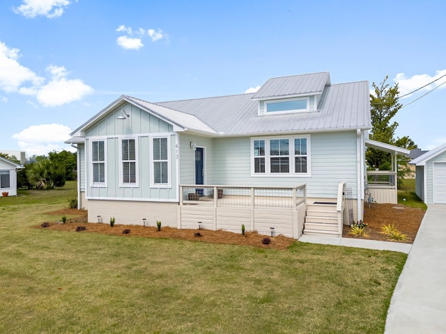 413 Colorado Dr, Mexico Beach, FL 32456 - view of front of property with board and batten siding, a front yard, and metal roof