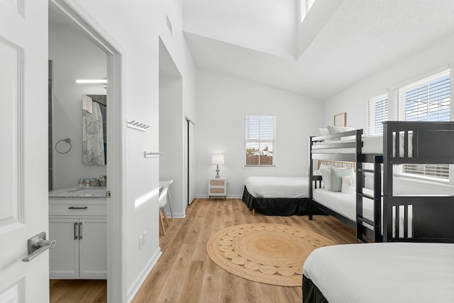 413 Colorado Dr, Mexico Beach, FL 32456 - bedroom with light wood-style floors, multiple windows, lofted ceiling, a sink, and baseboards