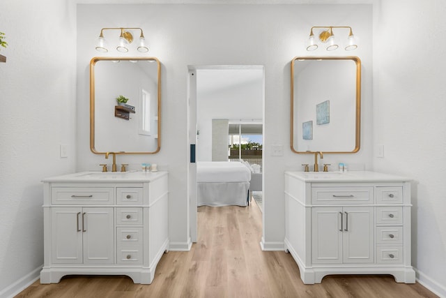 413 Colorado Dr, Mexico Beach, FL 32456 - full bathroom with wood finished floors, two vanities, baseboards, and a soaking tub