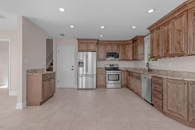 411-A Cobia Ave, Fort Walton Beach, FL 32548 - kitchen featuring appliances with stainless steel finishes, recessed lighting, light stone countertops, brown cabinets, and light tile patterned flooring