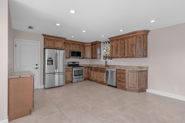 411-A Cobia Ave, Fort Walton Beach, FL 32548 - kitchen with appliances with stainless steel finishes, light stone countertops, recessed lighting, and brown cabinetry
