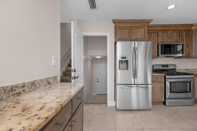411-A Cobia Ave, Fort Walton Beach, FL 32548 - kitchen with appliances with stainless steel finishes, light stone counters, light tile patterned floors, brown cabinetry, and recessed lighting