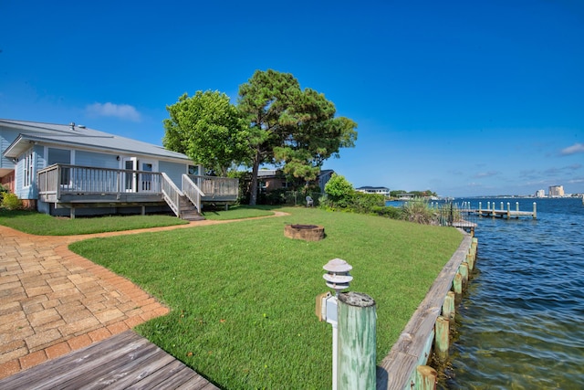411-A Cobia Ave, Fort Walton Beach, FL 32548 - view of green lawn featuring an outdoor fire pit, a boat dock, and a deck with water view